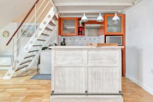 a kitchen with white cabinets and a staircase at Appartement face mer et Piscine in Le Croisic +21 photos
