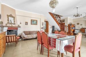 a dining room with a glass table and chairs at Barba Panais' House in Vonitsa