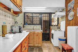 a kitchen with wooden cabinets and white appliances at Barba Panais' House in Vonitsa +24 photos