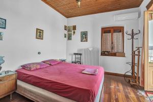 a bedroom with a large bed with a red blanket at Barba Panais' House in Vonitsa