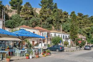 a street with a blue umbrella and some buildings at Barba Panais' House in Vonitsa