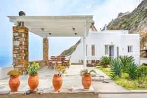 a patio with orange flower pots in front of a house at Blue and White in Otziás