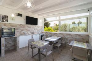 a kitchen with tables and chairs and a large window at Corallo House in Polignano a Mare