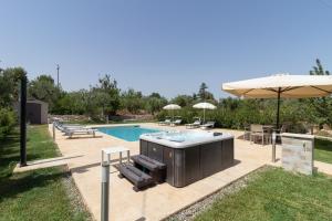 a hot tub and an umbrella next to a pool at Corallo House in Polignano a Mare