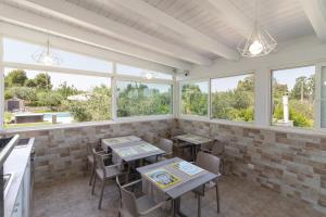a dining room with tables and chairs and windows at Corallo House in Polignano a Mare