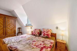 a bedroom with a bed with floral sheets and pillows at Ferienwohnung Kaffee-Mühle in Sponheim