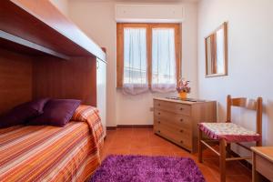 a bedroom with a bed and a dresser and a window at Casa Sara Lu Bagnu in Castelsardo