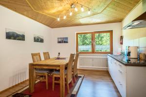 a kitchen with a wooden table and wooden ceilings at Tobelbach in Weiler-Simmerberg