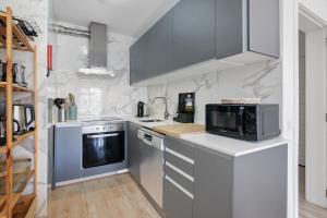 a kitchen with a microwave oven and a stove at Abertura Mar Zen in Quarteira +13 photos