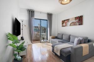 a living room with a couch and a tv at Abertura Mar Zen in Quarteira