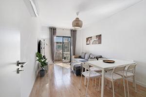a living room with a table and a couch at Abertura Mar Zen in Quarteira
