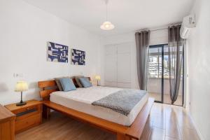 a bedroom with a bed and a large window at Abertura Mar Zen in Quarteira