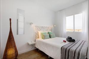 a white bedroom with a bed and a window at Casa Alisios in Costa Calma