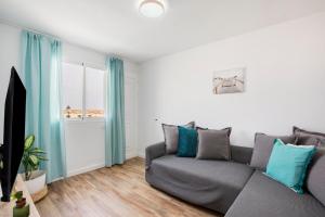 a living room with a gray couch and a window at Casa Alisios in Costa Calma