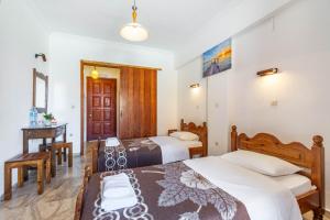 a bedroom with two beds and a table and a desk at Mires House Side Ground Floor 4 in Agios Gordios