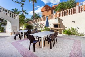 a patio with tables and chairs and a fireplace at 5 bedroom Villa private pool in Orihuela Costa