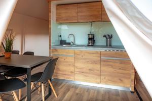 a kitchen with wooden cabinets and a table and chairs at Safarizelt in Großenbrode