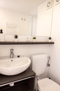 a white bathroom with a sink and a toilet at Safarizelt in Großenbrode