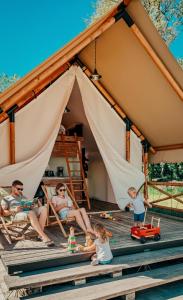 a family playing in front of a tent at Safarizelt in Großenbrode