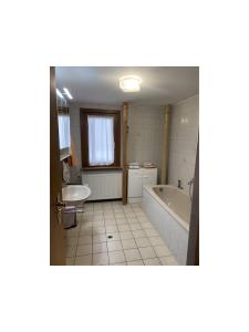 a bathroom with a tub and a sink at Ferienwohnung Wernet in Schönwald +8 photos