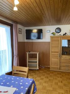 a room with a table and a tv on the wall at Ferienwohnung Wernet in Schönwald