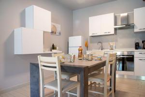 a kitchen with a wooden table and white cabinets at Il sole di calde Lago maggiore 504 in Castelveccana