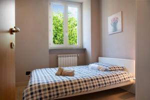 a small bedroom with a bed with a window at Il sole di calde Lago maggiore 504 in Castelveccana