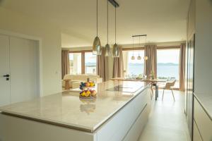 a kitchen with a counter with a bowl of fruit on it at Kožino Bay Lodge - Brand New Seaside Apartments, Heated Pool in Kožino