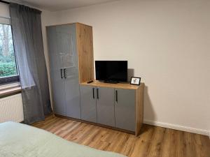 a bedroom with a cabinet with a television on it at Ahlers am Wald in Edewecht
