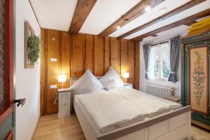 a bedroom with a bed in a room with wooden walls at Altes Zollhüsli in Schluchsee