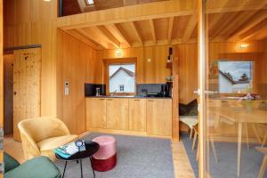 a living room with wood paneling and a kitchen at Tinyhaus am Bussen in Unlingen +22 photos