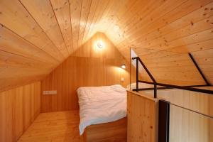 a small room with a bed in a wooden ceiling at Tinyhaus am Bussen in Unlingen