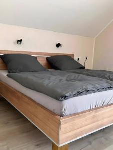 a bed with a wooden frame in a bedroom at Pure Vista Hank Schwarzwaldblick in Luttingen