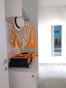 a suitcase and a hat on a shelf in a room at Vichi's nest in Pianello Del Lario