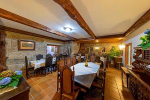 a dining room with tables and chairs and a stone wall at Casa de Valdemar in Felgueiras
