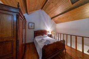 a bedroom with a bed and a wooden ceiling at Casa de Valdemar in Felgueiras +35 photos
