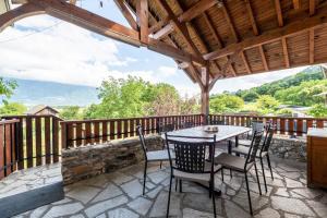 a patio with a table and chairs on a deck at Gîte le Chamoyard in Chamoux-sur-Gelon