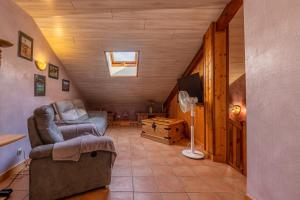 a living room with a couch and a chair in a house at Gîte le Chamoyard in Chamoux-sur-Gelon