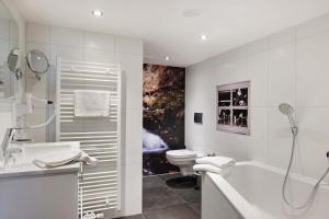 a white bathroom with a tub and a toilet at Bäuerleshütte in Breitnau +28 photos