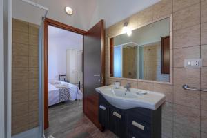 a bathroom with a sink and a mirror at Casa Ginestre piscina e vista mare in Aglientu +20 photos