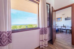 a hallway with a large window and a dining room at Casa Ginestre piscina e vista mare in Aglientu