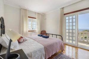 a bedroom with a bed and a large window at Casa Dona Lola in Moledo +28 photos