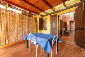 a dining room with a blue table and chairs at Appartamento Pinus in Santa Margherita di Pula