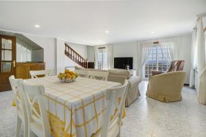 a dining room and living room with a table and chairs at Casa Dona Lola in Moledo