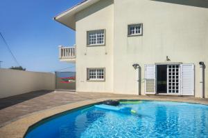a swimming pool in front of a house at Casa Dona Lola in Moledo