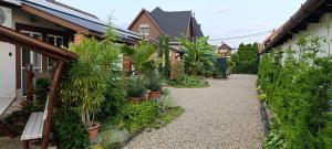 a walkway with plants in pots next to a building at CSABA-EMILKA-SPA Apartmanok in Hajdúszoboszló