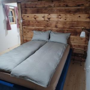 a large bed in a room with a wooden wall at Zlatibor Koliba Laki in Zlatibor