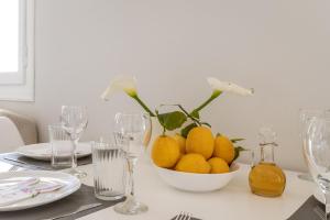 a table with a bowl of lemons on a table with glasses at Stenies'nook in Andros