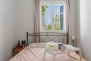 a bedroom with a bed with a table and a window at Stenies'nook in Andros