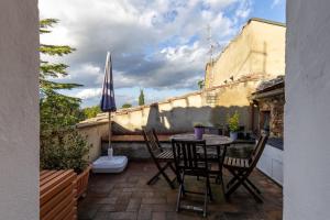 a patio with a table and chairs and an umbrella at Casa Al Cantone in Certaldo